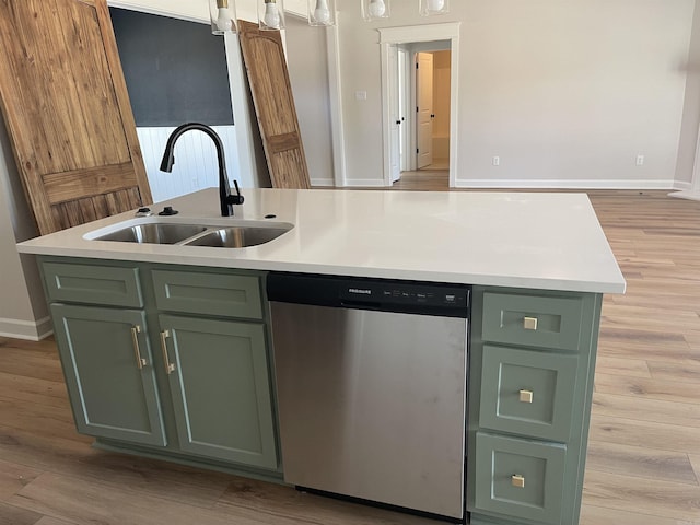 kitchen featuring an island with sink, a sink, stainless steel dishwasher, light countertops, and green cabinetry