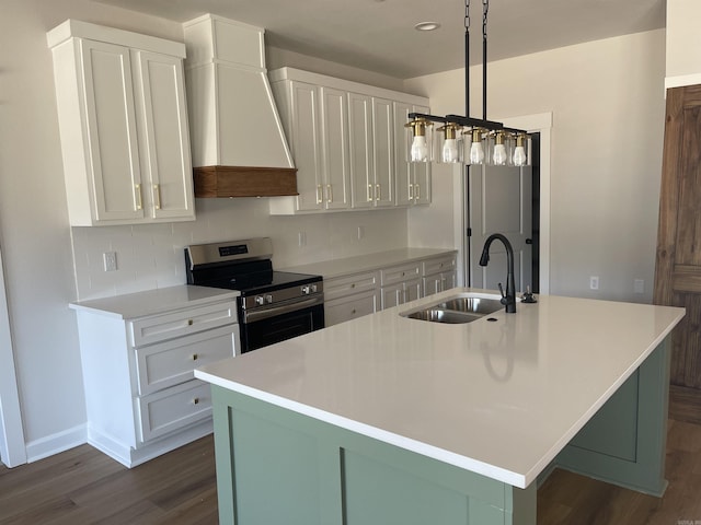 kitchen featuring premium range hood, dark wood-type flooring, a kitchen island with sink, a sink, and stainless steel electric range