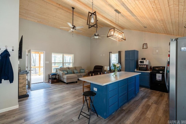 kitchen with blue cabinetry, ceiling fan, a breakfast bar area, freestanding refrigerator, and black electric range