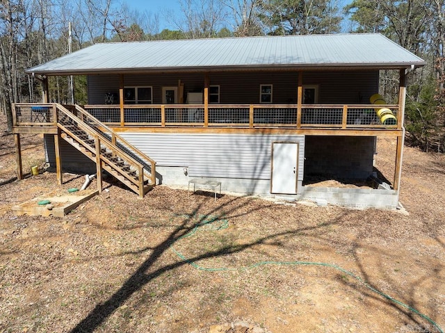 exterior space with a wooden deck, stairway, and metal roof