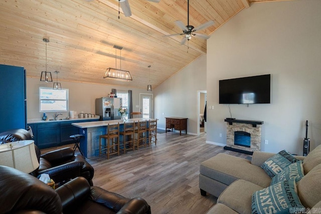 living area featuring high vaulted ceiling, wood finished floors, baseboards, wood ceiling, and ceiling fan