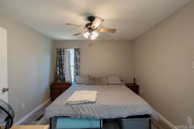 bedroom with visible vents, ceiling fan, baseboards, and wood finished floors