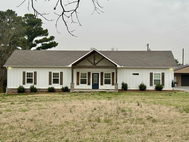 view of front of home with a garage, a front lawn, and roof with shingles