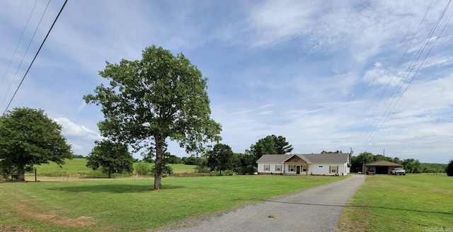 view of front of property with a carport and a front lawn