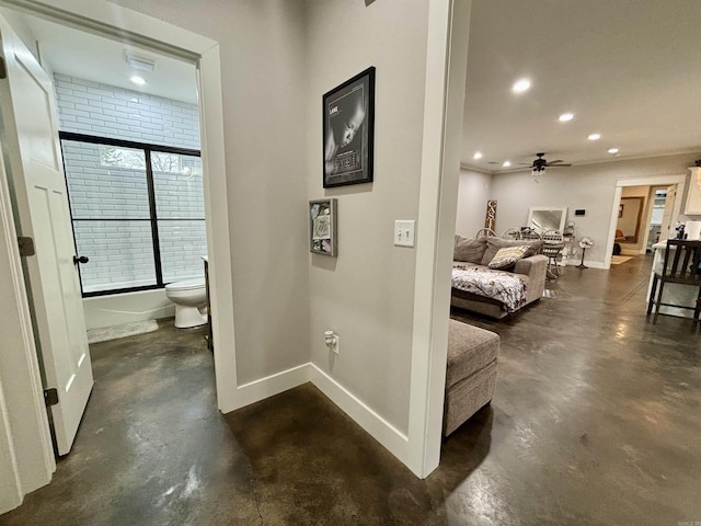 corridor with recessed lighting, finished concrete flooring, and baseboards