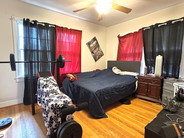 bedroom featuring baseboards, light wood-style flooring, and a ceiling fan