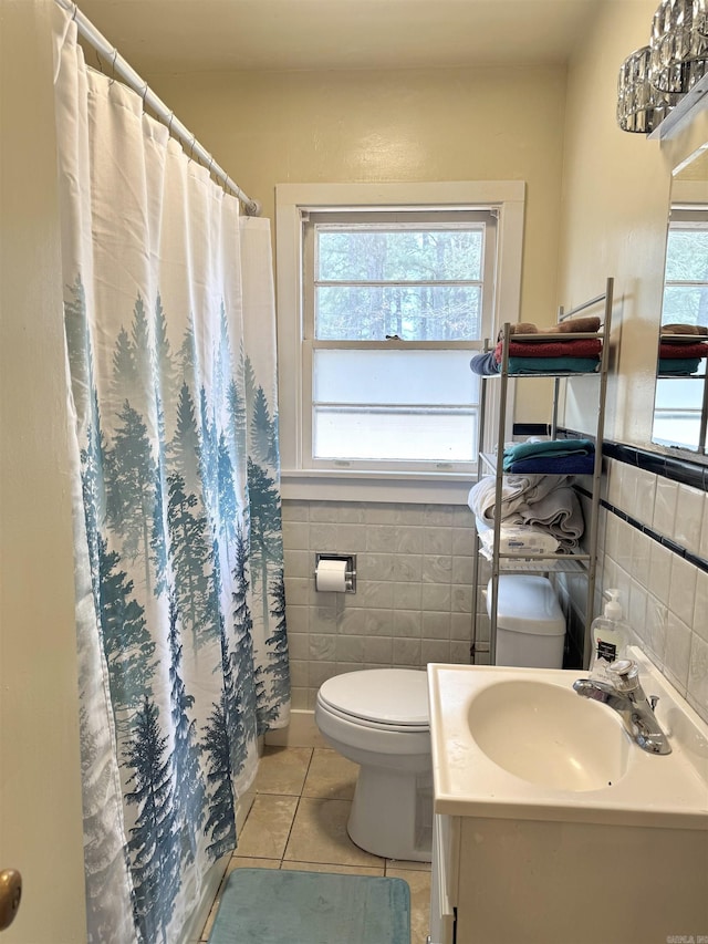 bathroom featuring toilet, tile walls, wainscoting, and tile patterned flooring