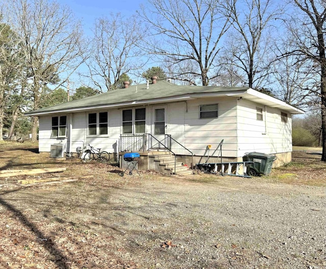 view of front of home with central AC unit and a chimney