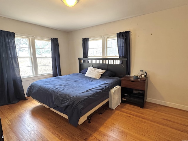 bedroom with baseboards and light wood-style flooring