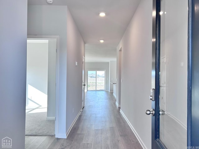 hall featuring baseboards and wood finished floors