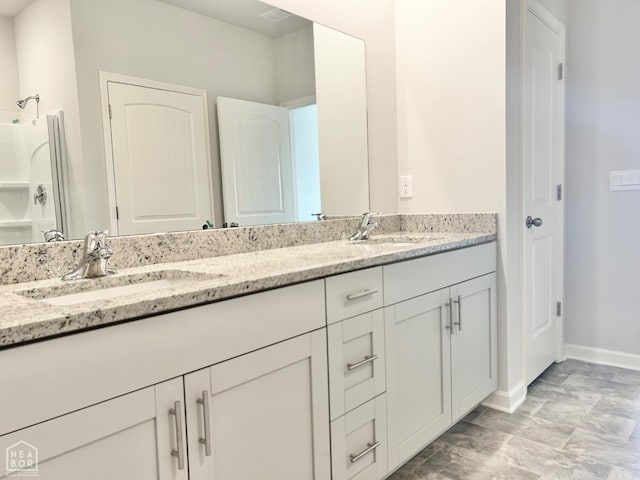 bathroom with a sink, baseboards, and double vanity