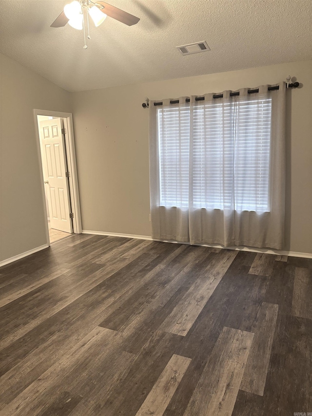 spare room with visible vents, wood finished floors, a textured ceiling, and ceiling fan