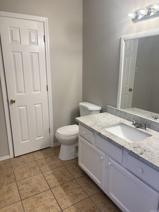 half bath featuring tile patterned flooring, toilet, and vanity