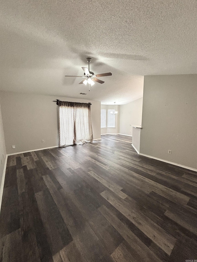 empty room with dark wood finished floors, a textured ceiling, baseboards, and ceiling fan