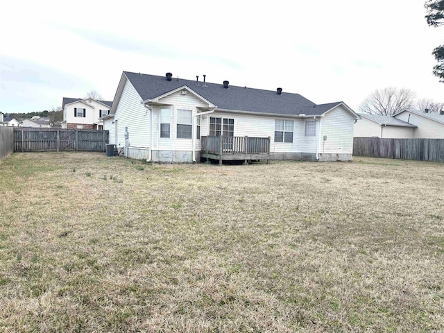 back of property with a fenced backyard, a deck, cooling unit, and a yard