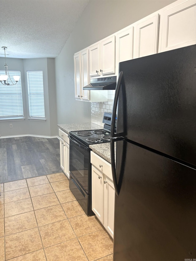 kitchen with white cabinetry, black appliances, under cabinet range hood, lofted ceiling, and a textured ceiling