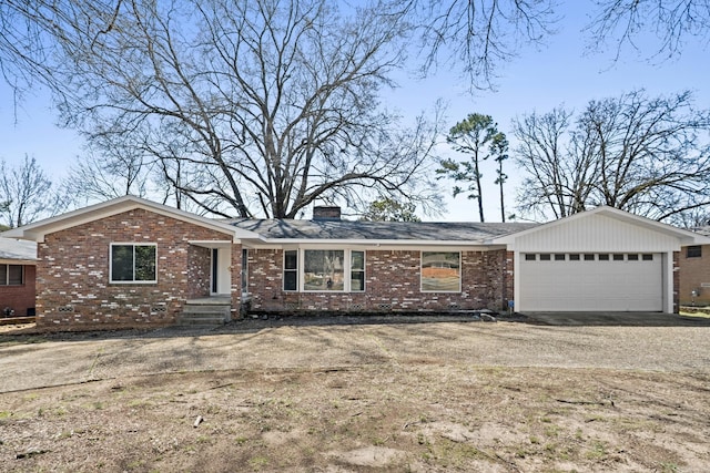 ranch-style home featuring dirt driveway, brick siding, a chimney, and an attached garage