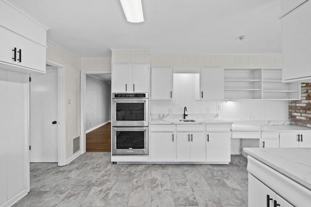 kitchen featuring open shelves, double oven, ornamental molding, and white cabinetry