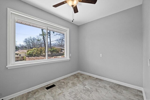 spare room with visible vents, baseboards, and ceiling fan