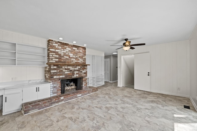 unfurnished living room with a fireplace and ceiling fan