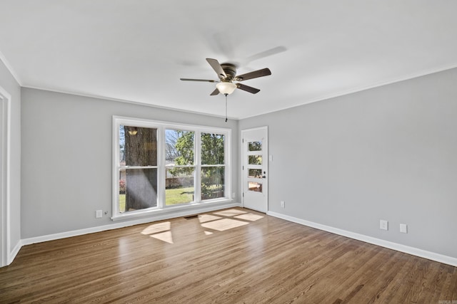 empty room featuring baseboards, wood finished floors, ceiling fan, and ornamental molding