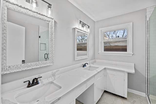 full bath with a sink, baseboards, a stall shower, and double vanity