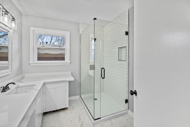 bathroom featuring a shower stall, vanity, marble finish floor, and baseboards