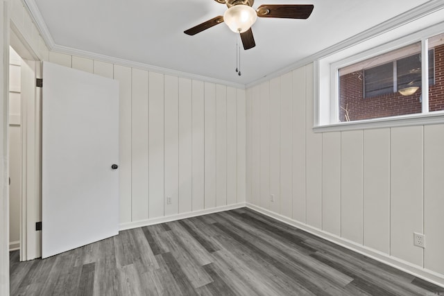 unfurnished room featuring a ceiling fan, crown molding, wood finished floors, and baseboards