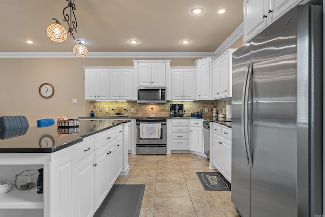 kitchen featuring dark countertops, white cabinetry, appliances with stainless steel finishes, crown molding, and decorative backsplash