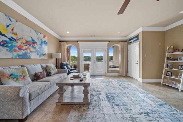 living room with ornamental molding, french doors, arched walkways, baseboards, and ceiling fan