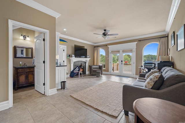 living room with light tile patterned floors, baseboards, ceiling fan, ornamental molding, and french doors