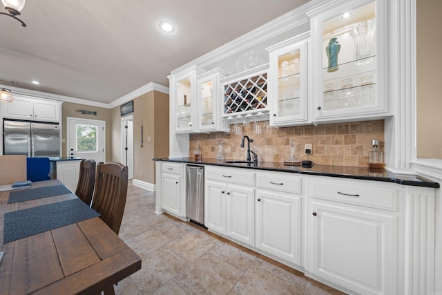 kitchen featuring ornamental molding, a sink, backsplash, dark countertops, and built in fridge