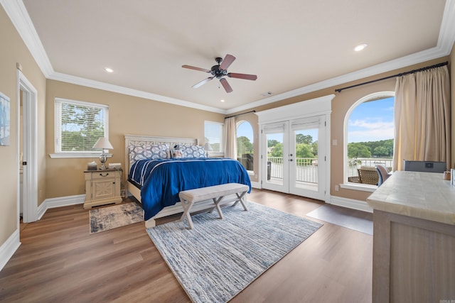 bedroom with french doors, wood finished floors, crown molding, and access to outside