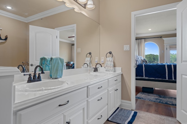 ensuite bathroom featuring a sink, double vanity, ensuite bathroom, and crown molding