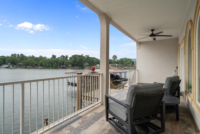 balcony with ceiling fan and a water view