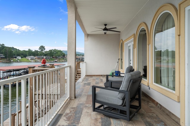 balcony with ceiling fan and a water view