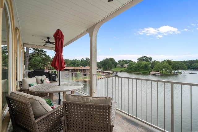 balcony with ceiling fan and a water view