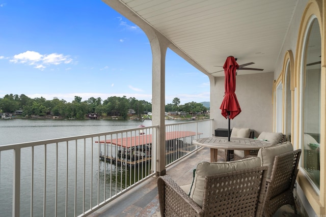 balcony featuring a ceiling fan and a water view