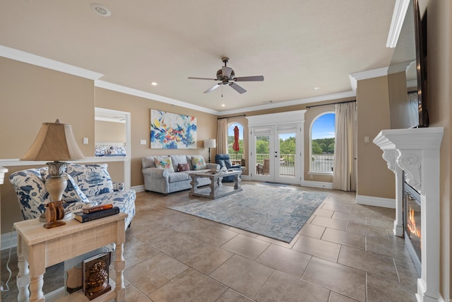 tiled living room featuring ornamental molding, a glass covered fireplace, french doors, baseboards, and ceiling fan