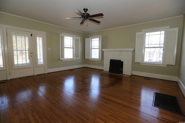 unfurnished living room with visible vents, a ceiling fan, a brick fireplace, and crown molding