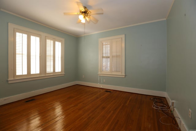 empty room featuring visible vents, crown molding, ceiling fan, baseboards, and hardwood / wood-style floors