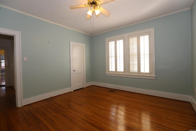 spare room featuring a ceiling fan, crown molding, wood finished floors, and baseboards