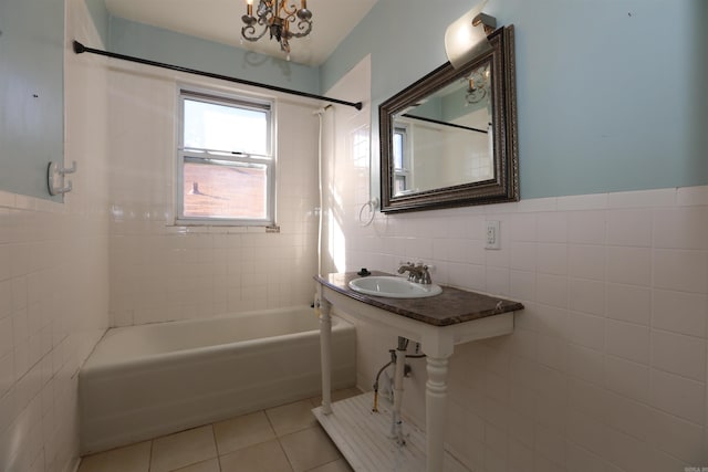 full bath featuring tile patterned flooring, bathing tub / shower combination, an inviting chandelier, tile walls, and a sink