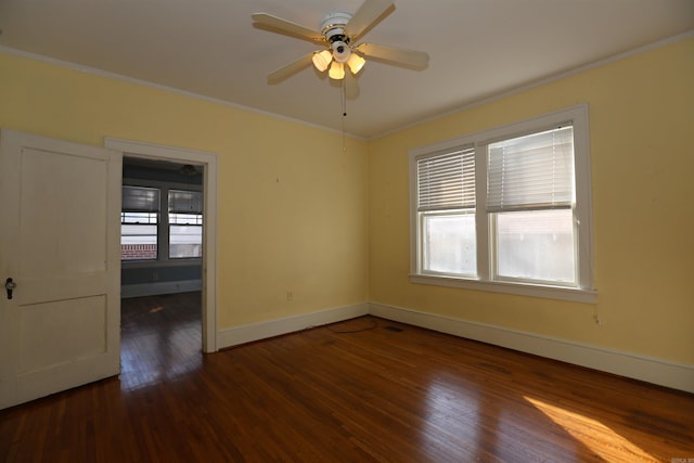 empty room with baseboards, a ceiling fan, wood finished floors, and crown molding