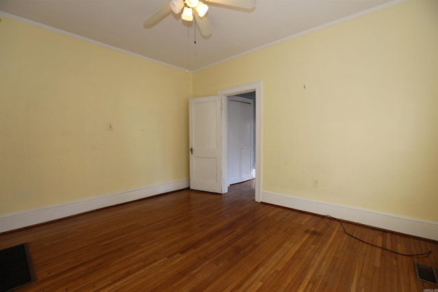 spare room featuring ceiling fan, visible vents, dark wood finished floors, and crown molding