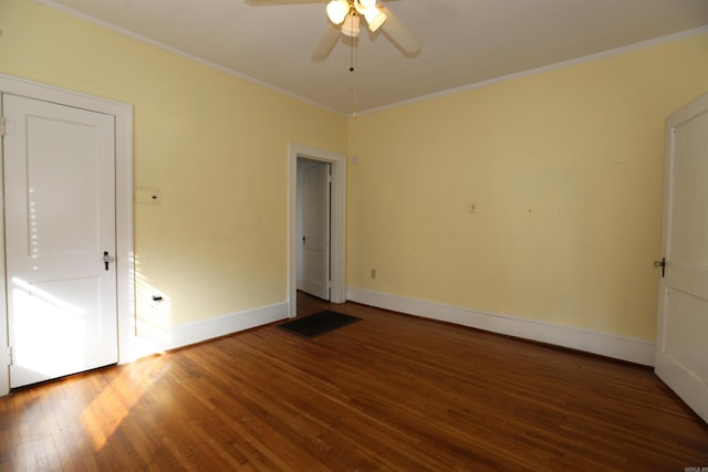 empty room with baseboards, wood finished floors, ornamental molding, and a ceiling fan