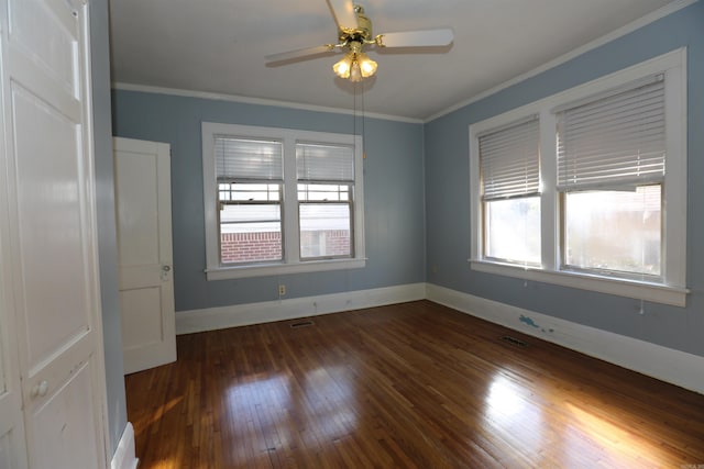 spare room featuring baseboards, visible vents, ceiling fan, wood-type flooring, and crown molding