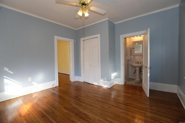 unfurnished bedroom featuring ornamental molding, a ceiling fan, hardwood / wood-style floors, a closet, and baseboards