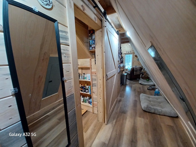 hallway featuring a barn door and wood finished floors