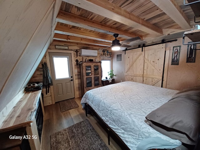 bedroom with an AC wall unit, a barn door, beam ceiling, wooden ceiling, and wood finished floors